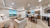 Located on S Heritage Way in Andover, Kansas, this well-appointed 3-bedroom, 2-bathroom single-floor residence offers a thoughtfully designed layout with modern finishes throughout. Light wood-tone luxury vinyl plank flooring flows seamlessly across the entire space, complemented by neutral walls and dark-trimmed doorframes that add a contemporary contrast.

The open-concept kitchen and living area serves as the heart of the home, featuring rich dark wood cabinetry, granite countertops, stainless steel appliances, and a classic white subway tile backsplash. A central island provides additional workspace and casual dining. Recessed lighting and large windows bathe the combined living and kitchen area in natural light, offering pleasant outdoor views.

The primary bedroom is generously sized, boasting a large picture window with scenic views and a ceiling fan. Its en-suite bathroom includes a dual-sink vanity with granite countertops and ample cabinetry. A spacious walk-in closet with wire shelving provides excellent storage. The additional bedrooms are bright and well-proportioned, each with large windows overlooking the outdoors. A wide hallway connects all rooms, enhancing the open and accessible feel of the floor plan. Two closets and two full bathrooms round out this comfortable and functional residence.