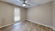 Located at 102 Brentway Cir in Knoxville, Tennessee, this single-floor, 2-bedroom, 2-bathroom residence offers a clean, modern aesthetic throughout. Wood-look plank flooring flows consistently across the space, complemented by neutral gray-toned walls and crisp white trim, creating a cohesive and contemporary feel.

The living room is bright and open, featuring a sliding glass door with vertical blinds that invite natural light and provide outdoor views. The combined kitchen and dining area is well-equipped with stainless steel appliances, granite-style countertops, white cabinetry, and a skylight overhead that further brightens the space. A pantry provides convenient additional storage.

Both bedrooms are comfortably sized, each outfitted with ceiling fans and closets featuring louvered bi-fold doors. The spacious primary bedroom includes a generous closet and natural light from a window. The two bathrooms feature granite-topped vanities with mirrors, maintaining the consistent modern finishes found throughout the home.

A central hallway connects the rooms efficiently, with four closets distributed throughout for ample storage. The utility room houses an in-unit washer, and a dedicated entrance completes the layout. This residence offers practical, move-in-ready living with thoughtful details throughout.
