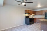 Located at 12555 Pine St in Taylor, Michigan, this two-story home offers three bedrooms and two bathrooms thoughtfully distributed across two floors. The main level centers around a combined kitchen and living area, where wood-look flooring and a ceiling fan create a bright, functional atmosphere. The kitchen is well-appointed with warm-toned wood cabinetry, a mosaic tile backsplash, black appliances including a gas range, dishwasher, and refrigerator, as well as a peninsula countertop that provides additional prep and dining space. The open layout allows the kitchen to flow seamlessly into the living area, enhancing the sense of space on the main floor. Upstairs, the three carpeted bedrooms offer comfortable retreats, with the generously sized primary bedroom featuring vaulted ceiling lines and direct access to a hallway. Additional bedrooms include natural light from windows with vertical blinds and ample closet storage, including a double sliding-door closet. The two bathrooms are clean and functional, one featuring a full tub-shower combo with white subway tile surround and chrome fixtures. Hallways on both floors connect each space efficiently, completing this well-structured and practical home.