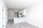 Located at 342 W Girard Ave in Philadelphia's vibrant Northern Liberties neighborhood, this thoughtfully designed 2-bedroom, 1-bathroom unit offers a clean, modern aesthetic across a single floor. Light hardwood flooring flows seamlessly throughout, complementing the crisp white walls and abundant natural light that brighten every room.

The kitchen is a standout feature, equipped with a full suite of stainless steel appliances including a refrigerator, electric range, microwave, and dishwasher. White shaker-style upper cabinets pair with gray lower cabinets, while a marble-veined quartz countertop and peninsula provide ample prep and dining space. Pendant lighting adds a stylish finishing touch.

The open layout connects the kitchen to the living area, creating a functional and airy flow. Both bedrooms are comfortably sized, featuring large windows that invite natural light, hardwood floors, and built-in closets with shelving for practical storage. The primary bedroom offers a well-organized reach-in closet.

The bathroom is finished with large-format marble-style floor tiles, full-wall tiled tub and shower surround with a sliding glass door, and a modern floating vanity. Clean lines and neutral tones create a calm, spa-like atmosphere. This unit combines contemporary finishes with efficient design throughout.