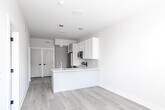 Located at 342 W Girard Ave in Philadelphia's vibrant Northern Liberties neighborhood, this thoughtfully designed 2-bedroom, 1-bathroom unit offers a clean, modern aesthetic across a single floor. Light hardwood flooring flows seamlessly throughout, complementing the crisp white walls and abundant natural light that brighten every room.

The kitchen is a standout feature, equipped with a full suite of stainless steel appliances including a refrigerator, electric range, microwave, and dishwasher. White shaker-style upper cabinets pair with gray lower cabinets, while a marble-veined quartz countertop and peninsula provide ample prep and dining space. Pendant lighting adds a stylish finishing touch.

The open layout connects the kitchen to the living area, creating a functional and airy flow. Both bedrooms are comfortably sized, featuring large windows that invite natural light, hardwood floors, and built-in closets with shelving for practical storage. The primary bedroom offers a well-organized reach-in closet.

The bathroom is finished with large-format marble-style floor tiles, full-wall tiled tub and shower surround with a sliding glass door, and a modern floating vanity. Clean lines and neutral tones create a calm, spa-like atmosphere. This unit combines contemporary finishes with efficient design throughout.