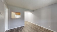 Located at 910 E 61st St S in Tulsa, Oklahoma, this one-bedroom, one-bathroom unit offers a practical and well-organized single-floor layout. The kitchen is efficiently designed with warm wood-toned cabinetry, light countertops, wood-look flooring, and white appliances including a coil-burner range, refrigerator, and dishwasher. A built-in pantry closet provides convenient additional storage within the kitchen area. The bedroom is a comfortable, quiet retreat finished with neutral gray walls, soft carpeting, and a textured ceiling. A window allows natural light to filter in, brightening the space. The bedroom connects directly to both a dedicated closet and the full bathroom, offering a practical flow. The bathroom features wood-look tile flooring, a warm wood vanity with an integrated sink, a large wall mirror, a lighted vanity fixture, an overhead medicine cabinet, and a full bathtub. Throughout the unit, neutral tones and clean finishes create a cohesive and move-in-ready atmosphere. The efficient floor plan makes thoughtful use of every square foot, making this unit a functional and comfortable living space in a convenient Tulsa location.