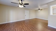 Located at 179 N Royal Oaks Blvd in Franklin, TN, this two-bedroom, two-bathroom residence offers a well-designed single-level layout with a functional and comfortable feel throughout. The open living area greets you with warm wood-look flooring, dual ceiling fans, and French doors that invite natural light and outdoor views. A pass-through connects the living space to the galley-style kitchen, which is outfitted with white shaker cabinetry, marble-look countertops, stainless steel appliances including a microwave, electric range, refrigerator, and dishwasher, plus a stainless sink. A dedicated pantry/storage closet adds convenience. Both bedrooms feature plush carpeting, ceiling fans with lighting, and double-door closets. The primary bedroom is generously sized and is accompanied by its own bathroom. The second bathroom is equally well-appointed, featuring a white vanity with marble-look countertops, oil-rubbed bronze fixtures, a framed mirror, and a tub-shower combination. Both bathrooms continue the wood-look flooring found throughout the main living areas. Neutral warm beige tones on the walls and textured ceilings are consistent throughout, creating a cohesive and inviting atmosphere across the entire residence.
