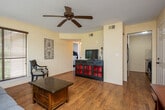 This well-appointed 1-bedroom, 1-bathroom unit offers an efficient and comfortable layout designed to maximize every square foot. The living room serves as the heart of the unit, featuring warm hardwood flooring, a textured ceiling, a ceiling fan, and multiple windows fitted with blinds that allow for natural light while maintaining privacy. The space is open enough to accommodate a seating area and additional furnishings with ease.

The kitchen is compact yet functional, showcasing light wood cabinetry, granite countertops, a tile backsplash in a classic diagonal pattern, and black appliances including a dishwasher and range. Hardwood flooring continues seamlessly from the living area into the kitchen.

The bedroom is carpeted for comfort and includes a ceiling fan, multiple windows for natural light, and closet access, providing a quiet and restful retreat. The full bathroom features tile flooring, a shower-tub combination, a stylish vanity with a dark countertop, and classic wall décor.

A standout feature of this unit is the private balcony, which overlooks a lush, tree-lined outdoor setting with open green space and views of the surrounding community. Access is provided via an exterior metal staircase with railing. Two closets offer practical storage throughout the unit.