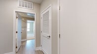 Located at 232 S San Pedro Street in the heart of downtown Los Angeles, this two-bedroom, two-bathroom residence offers a thoughtfully designed single-level layout with a clean, contemporary aesthetic. Light wood-style flooring runs throughout the main living areas, lending a bright and cohesive feel to the space.

The kitchen is a standout feature, equipped with stainless steel appliances including a gas range, microwave, and refrigerator. Dark espresso cabinetry contrasts sharply with white quartz countertops, and a peninsula with pendant lighting provides both additional prep space and a casual dining option. Windows at the far end of the living area allow natural light to filter in, with views of surrounding greenery.

Both bedrooms are carpeted in neutral tones, creating a comfortable and quiet retreat. The primary bedroom is a well-proportioned room featuring large windows dressed with blinds. The secondary bedroom is similarly sized and bright. A dedicated closet and hallway connect the private areas of the residence efficiently.

The two bathrooms are finished consistently, each featuring a tub-shower combination with clean white tile surrounds, dark wood-toned vanity cabinetry, white countertops, and light wood-style flooring. The overall palette throughout the residence—warm beige walls, neutral carpeting, and modern fixtures—creates a calm, move-in-ready environment.