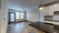 Located at 1401 Satellite View in Round Rock, Texas, this single-floor residence offers a thoughtfully designed open-concept layout with clean, contemporary finishes throughout. The kitchen serves as a central hub of the home, showcasing dark granite countertops, a center island with pendant lighting, crisp white cabinetry, a subway tile backsplash, and a full suite of stainless steel appliances. Wood-look flooring flows seamlessly through the main living areas, complementing the bright, neutral color palette. The spacious living area benefits from natural light streaming through large windows with blinds and features a ceiling fan for year-round comfort, along with convenient access to an exterior door. Bedrooms are carpeted for warmth and comfort, with generous windows that bring in abundant natural light. The bathrooms are well-finished, with one featuring a full soaking tub and shower combination with classic white subway tile surround, and another offering a streamlined vanity with wood-look tile flooring. A dedicated in-unit laundry area houses a full-size washer and dryer set with overhead shelving for added storage. The overall ambiance is modern and functional, offering a comfortable living environment in a well-connected Round Rock location.