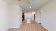 Located at 101 Madison Avenue in Athens, GA, this one-bedroom, one-bathroom unit offers a thoughtfully designed single-floor layout with a clean, modern aesthetic. Light wood-style flooring flows continuously throughout the space, complemented by crisp white walls and recessed lighting that create a bright, welcoming atmosphere.

The open-concept kitchen and living area form the heart of the unit. The kitchen is equipped with rich cherry-toned cabinetry extending to the ceiling for ample storage, black appliances including a gas range, built-in microwave, and refrigerator, as well as a granite-topped island that provides additional prep space and serves as a natural divider between the kitchen and the spacious living area. A ceiling fan keeps the living room comfortable and airy.

The bedroom is a well-proportioned retreat featuring a ceiling fan, natural light from multiple windows with blinds, and direct access to a dedicated closet. The bathroom is finished with large-format tile flooring, a rich wood vanity topped with granite, a wall-length mirror, and a full soaking tub with tile surround and brushed nickel fixtures. The overall design emphasizes functionality and clean finishes throughout every room.