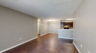 This single-floor, 2-bedroom, 2-bathroom residence offers a practical and comfortable layout designed for everyday living. The open living and dining area is anchored by rich, dark wood-look flooring that flows throughout the main living spaces, creating a cohesive and warm aesthetic. Neutral gray-toned walls complement the flooring and provide a versatile backdrop throughout.

The kitchen is well-equipped with dark espresso cabinetry, light stone-look countertops, a black electric range, and a mosaic tile backsplash that adds a decorative touch. It connects seamlessly to the dining area, making it ideal for entertaining.

The living room features a sliding glass door with vertical blinds, allowing natural light to fill the space and providing outdoor access. Both bedrooms feature plush carpeting and neutral walls. The generously sized primary bedroom includes a ceiling fan with light fixture, a dedicated walk-in closet, and direct access to one of the two bathrooms. The second bedroom receives natural light through a window and also features soft carpeting.

Both bathrooms are finished with wood-look flooring, light countertops, and full tub-shower combinations. The residence also includes two closets for additional storage, rounding out a thoughtfully organized floor plan.