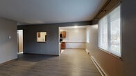 Located at 1820 Garden Ridge Dr in Toledo, OH, this 2-bedroom, 1-bathroom unit offers a practical and comfortable single-floor layout. The open-concept living and dining area is finished with durable wood-tone luxury vinyl plank flooring and neutral gray walls, creating a clean, move-in-ready aesthetic. Windows fitted with blinds allow natural light to filter in, while baseboard heating units run along the perimeter walls. A pass-through window connects the living area to the kitchen, enhancing the sense of openness between spaces. The galley-style kitchen is well-equipped with warm wood cabinetry, light countertops, a double-basin sink, and a full suite of black appliances including a refrigerator, electric range, and over-the-range microwave. Light tile flooring completes the kitchen's functional design. The primary bedroom offers a comfortable footprint with LVP flooring, a window for natural light, and closet access. The second bedroom mirrors a similar layout. The full bathroom features soft green walls, a single-sink vanity with wood cabinetry, and a full tub-shower combo. Four closets throughout the unit provide ample storage. The overall layout is efficient and well-organized, suited for everyday living.