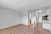 This studio in Colton, California, offers an efficiently designed single-floor layout that makes smart use of its compact footprint. The open main living area features wood-look laminate flooring and neutral gray walls, creating a clean, modern aesthetic that maximizes the sense of space and light throughout.

The kitchen is positioned at one end of the main area and is separated by a peninsular breakfast bar with a light granite-style countertop, providing both a functional workspace and a casual dining surface. The kitchen is well-equipped with white cabinetry above and below the counter, a stainless steel double-basin sink, a gas range with overhead ventilation, a refrigerator, and a stainless steel dishwasher — offering full functionality within a compact footprint.

A dedicated walk-in closet provides generous storage with built-in shelving and hanging rods, a notable feature for a studio of this size. The bathroom is accessible through a short hallway off the main living area. Flush-mount and fluorescent lighting fixtures illuminate the kitchen and entry areas efficiently.

Overall, this studio presents a bright, straightforward layout with practical finishes, making it a functional and low-maintenance living space in Colton, CA.