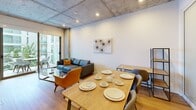 This contemporary apartment, located at #611 TENTEN Downtown, offers a spacious 850 square feet of living area on a single floor. The layout comprises 3 bedrooms, including a primary bedroom of 110 square feet, 2 bathrooms, and uniquely, 2 kitchens. The interior design showcases a blend of modern and industrial elements, with exposed concrete ceilings adding character to the space. Wooden floors throughout provide warmth and contrast to the sleek, white walls. The bedrooms feature built-in wardrobes with sliding doors, optimizing space usage. Bathrooms are designed with clean lines, featuring illuminated mirrors and glass shower enclosures. The kitchen boasts wooden cabinetry, stainless steel appliances, and under-cabinet lighting, creating a functional and stylish cooking area. The living and dining area is open-plan, with large windows allowing natural light to flood the space. Furnishings are minimalist and contemporary, complementing the overall design aesthetic. The apartment's layout and features make efficient use of the available space, offering a comfortable and modern urban living environment.