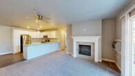 Located at 2523 Glen Ln in Sister Bay, Wisconsin, this well-appointed 2-bedroom, 2-bathroom single-floor residence offers a thoughtfully designed layout with modern finishes throughout. The open-concept living and kitchen area serves as the heart of the home, anchored by a striking stone-surround fireplace with a white mantel. Sliding glass doors allow natural light to pour in and provide direct outdoor access. The kitchen features crisp white shaker cabinetry, granite-look countertops, stainless steel appliances including a refrigerator, range, and microwave, along with a double-basin sink and pendant lighting over the breakfast bar. Hard surface flooring runs through the kitchen and bathrooms, while plush carpeting covers the living areas and bedrooms. Both bedrooms are comfortably sized, each equipped with ceiling fans, baseboard heating, and window blinds. The primary bedroom includes its own en-suite bathroom with a walk-in shower, white vanity, and granite countertop. The second bathroom mirrors the same clean aesthetic. Additional conveniences include four closets for generous storage and a dedicated laundry area, making this home both practical and comfortable in a charming Door County location.