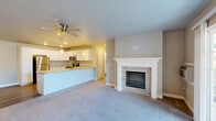 Located at 2523 Glen Ln in Sister Bay, Wisconsin, this well-appointed 2-bedroom, 2-bathroom single-floor residence offers a thoughtfully designed layout with modern finishes throughout. The open-concept living and kitchen area serves as the heart of the home, anchored by a striking stone-surround fireplace with a white mantel. Sliding glass doors allow natural light to pour in and provide direct outdoor access. The kitchen features crisp white shaker cabinetry, granite-look countertops, stainless steel appliances including a refrigerator, range, and microwave, along with a double-basin sink and pendant lighting over the breakfast bar. Hard surface flooring runs through the kitchen and bathrooms, while plush carpeting covers the living areas and bedrooms. Both bedrooms are comfortably sized, each equipped with ceiling fans, baseboard heating, and window blinds. The primary bedroom includes its own en-suite bathroom with a walk-in shower, white vanity, and granite countertop. The second bathroom mirrors the same clean aesthetic. Additional conveniences include four closets for generous storage and a dedicated laundry area, making this home both practical and comfortable in a charming Door County location.
