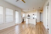 Located at 1223 East Plant Street in Winter Garden, FL, this well-appointed 2-bedroom, 2-bathroom residence offers a thoughtfully designed single-floor layout with a bright, open-concept living area. The combined dining room, kitchen, and living room creates a seamless flow, anchored by a modern kitchen featuring white shaker cabinetry, a marble-style subway tile backsplash, a center island with quartz countertops, stainless steel appliances, and stylish black pendant lighting. Durable hardwood-style flooring runs throughout the home, complementing the clean, neutral color palette. A ceiling fan and abundant natural light from multiple windows enhance the airy feel of the living space. The spacious primary bedroom includes generous walk-in closet space with built-in wire shelving. Both bathrooms are finished with white vanities, black hardware accents, and subway tile shower surrounds. Additional conveniences include a dedicated pantry and in-unit laundry. The private balcony offers pleasant views of the landscaped community surroundings. Panel-style interior doors and recessed lighting add refined finishing touches throughout this clean, contemporary residence.