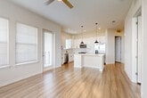 Located at 1223 East Plant Street in Winter Garden, FL, this well-appointed 2-bedroom, 2-bathroom residence offers a thoughtfully designed single-floor layout with a bright, open-concept living area. The combined dining room, kitchen, and living room creates a seamless flow, anchored by a modern kitchen featuring white shaker cabinetry, a marble-style subway tile backsplash, a center island with quartz countertops, stainless steel appliances, and stylish black pendant lighting. Durable hardwood-style flooring runs throughout the home, complementing the clean, neutral color palette. A ceiling fan and abundant natural light from multiple windows enhance the airy feel of the living space. The spacious primary bedroom includes generous walk-in closet space with built-in wire shelving. Both bathrooms are finished with white vanities, black hardware accents, and subway tile shower surrounds. Additional conveniences include a dedicated pantry and in-unit laundry. The private balcony offers pleasant views of the landscaped community surroundings. Panel-style interior doors and recessed lighting add refined finishing touches throughout this clean, contemporary residence.