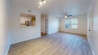 Located at 616 Suhtai Ct in Virginia Beach, Virginia, this thoughtfully updated single-floor unit offers a clean, modern aesthetic throughout. Light wood-style flooring runs seamlessly across the entire space, creating a bright and cohesive feel from room to room.

The open living area is well-lit by a combination of a ceiling fan with integrated light and track lighting, while a window allows natural light to fill the space with views of the surrounding greenery. A pass-through opening connects the living area directly to the kitchen, enhancing the open-concept flow.

The kitchen is a standout feature, showcasing crisp white shaker cabinetry with matte black hardware, a white subway tile backsplash, and sleek quartz countertops. Stainless steel appliances — including a refrigerator, electric range, and over-the-range microwave — complete the modern look, alongside a deep single-basin sink with a black flex-neck faucet.

The bedrooms are bright and well-proportioned, each featuring windows with blinds that invite natural light while maintaining privacy. The bathroom is finished in clean white tones with a full soaking tub and shower combo accented by matte black fixtures. A dedicated utility area houses a full-size washer and a water heater, adding practical convenience to the unit's overall functionality.