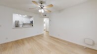 Located in Boca Raton, FL, this well-appointed one-bedroom, one-bathroom residence offers a clean, bright interior designed for comfortable everyday living. The single-floor layout makes efficient use of its space, with light wood-look flooring flowing through the main living areas, creating a cohesive and airy feel throughout.

The open living room is bathed in natural light from a large picture window with views of lush greenery outside. A ceiling fan with integrated lighting adds both comfort and a functional touch. The space flows naturally toward the combined dining and kitchen area, where a pass-through window connects the two zones seamlessly.

The kitchen is well-equipped with stainless steel appliances — including a refrigerator, range, microwave, and dishwasher — complemented by white cabinetry and a light countertop. Track lighting illuminates the workspace efficiently. A dedicated laundry area and an impressive five closets throughout the unit provide exceptional storage.

The bedroom features plush carpeting, a ceiling fan, and a window offering a peaceful green outdoor view. The full bathroom is bright and clean, complete with a tub-shower combination, a vanity with storage, and a large mirror. Textured ceilings are present throughout, adding a classic Florida residential character to the home.