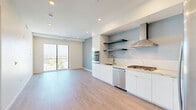 Located at 10375 Washington Blvd in the heart of Culver City, this modern one-bedroom, one-bathroom residence offers a thoughtfully designed open-concept layout with clean lines and contemporary finishes throughout. Light wood-tone flooring flows seamlessly across the entire unit, complementing the bright, neutral color palette.

The combined kitchen and living area forms the heart of the home. The kitchen is outfitted with a full suite of stainless steel appliances, including a built-in wall oven, microwave, gas cooktop, dishwasher, and a side-by-side refrigerator. Sleek white cabinetry, stone countertops, open floating shelves, and a stainless steel range hood complete the polished, modern aesthetic. Floor-to-ceiling sliding glass doors flood the living area with natural light and open directly onto a private balcony with open city views.

The bedroom is a comfortable, well-proportioned retreat featuring large windows, light wood floors, and a dedicated closet. The bathroom is finished with large-format tile, a frameless glass-enclosed walk-in shower, and clean, minimalist fixtures. Recessed lighting throughout the unit adds to the bright, airy ambiance, making this an efficient and stylish urban residence.