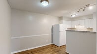 Located at 903 Kensington Ct in Cary, NC, this single-floor, 2-bedroom, 2-bathroom home offers a practical and well-appointed layout. Rich wood-look flooring runs throughout the main living areas, complemented by neutral gray walls and clean white trim that create a cohesive, modern aesthetic.

The kitchen is a functional highlight, featuring white shaker-style cabinetry, granite countertops, a peninsula with breakfast bar seating, and a suite of white appliances. It opens conveniently toward the living and dining area, making the space feel connected and efficient.

The living area is bright and airy, anchored by sliding glass doors that open to a private outdoor deck, offering views of the surrounding neighborhood and greenery — a standout feature of the home.

Both bedrooms are carpeted for comfort and include closets for storage. The primary bedroom is generously sized with access to its own dedicated space, while the secondary bedroom features a window with natural light and a sliding closet. Each bedroom benefits from its own bathroom: one includes a tub-shower combination with white tile surround, while the other is neatly appointed with a vanity and toilet.

The entrance and hallway provide smooth transitions between rooms, completing a thoughtfully organized floor plan suited for comfortable everyday living.
