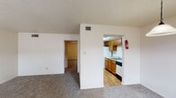 This single-floor unit in Port Arthur, TX is a 1-bedroom, 1-bathroom residence thoughtfully designed for comfortable everyday living. The entryway features wood-look flooring and is flanked by two windows fitted with horizontal blinds, allowing natural light to fill the space upon entry. The open living area is carpeted and connects seamlessly to the rest of the unit, with a textured ceiling throughout adding a classic residential character. A ceiling fan with a light fixture in the bedroom provides added comfort, and a sliding glass door with vertical blinds opens to an outdoor patio with a pleasant view of mature trees. The galley-style kitchen is well-equipped with warm wood cabinetry, ample upper and lower storage, light-toned countertops, a stainless steel sink, a white electric range, refrigerator, and a dishwasher — all set over easy-care wood-look flooring. The bathroom is clean and functional, featuring a full tub and shower combination with white tile surround, a toilet, vanity, and wood-look flooring with a grab bar for added safety. Central HVAC vents are present throughout, ensuring year-round climate control. This unit delivers a straightforward, well-maintained layout suited for individuals or couples seeking a manageable, move-in ready home.