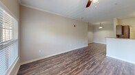 Located at 245 Creekwood Cove Ln in Lenoir City, Tennessee, this one-bedroom, one-bathroom residence offers a thoughtfully organized single-floor layout. The open-concept living and kitchen area serves as the heart of the home, featuring rich hardwood-style flooring, crown molding, and a ceiling fan with light fixture. Natural light flows in through a large window, adding warmth to the space. The kitchen is well-appointed with rich dark wood cabinetry, granite-style countertops, stainless steel appliances including a refrigerator, range, microwave, and dishwasher, all complemented by light wood-style flooring. The bedroom offers comfortable carpeting, a ceiling fan, a window with outdoor views, and a closet with wire shelving for organized storage. A dedicated walk-in closet area provides additional shelving and hanging space. The bathroom includes a full tub and shower combination with tile surround and brushed nickel grab bars and fixtures, set atop classic tile flooring. A dedicated laundry room accommodates a full-size washer and dryer side by side, adding everyday convenience. This well-maintained residence combines functional design with practical amenities throughout.