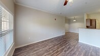 Located at 245 Creekwood Cove Ln in Lenoir City, Tennessee, this one-bedroom, one-bathroom residence offers a thoughtfully organized single-floor layout. The open-concept living and kitchen area serves as the heart of the home, featuring rich hardwood-style flooring, crown molding, and a ceiling fan with light fixture. Natural light flows in through a large window, adding warmth to the space. The kitchen is well-appointed with rich dark wood cabinetry, granite-style countertops, stainless steel appliances including a refrigerator, range, microwave, and dishwasher, all complemented by light wood-style flooring. The bedroom offers comfortable carpeting, a ceiling fan, a window with outdoor views, and a closet with wire shelving for organized storage. A dedicated walk-in closet area provides additional shelving and hanging space. The bathroom includes a full tub and shower combination with tile surround and brushed nickel grab bars and fixtures, set atop classic tile flooring. A dedicated laundry room accommodates a full-size washer and dryer side by side, adding everyday convenience. This well-maintained residence combines functional design with practical amenities throughout.