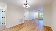 Located at 6 Parker Mathusa Place in Delmar, NY, this single-floor, 2-bedroom, 1-bathroom home offers a well-designed layout with a clean, neutral aesthetic throughout. The open living and dining area features warm light hardwood flooring, a ceiling fan, and a decorative chandelier, creating a bright and welcoming atmosphere with natural light filtering in through windows that overlook the surrounding greenery. The kitchen is efficiently designed with light maple cabinetry, granite countertops, stainless steel appliances, and matching hardwood floors, providing both style and functionality. The two bedrooms are carpeted for comfort, each equipped with ceiling fans and closets — the primary bedroom is notably spacious with a large window that frames outdoor views. The full bathroom is finished with tile flooring, a pedestal sink, a medicine cabinet with vanity lighting, and a clean, classic design. The attached garage features drywall-finished walls and an automatic opener, offering secure and convenient parking or additional storage space. Panel-style interior doors with dark hardware are found throughout, adding a consistent, refined touch to this move-in-ready Delmar home.