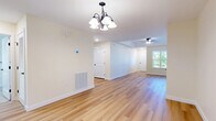 Located at 6 Parker Mathusa Place in Delmar, NY, this single-floor, 2-bedroom, 1-bathroom home offers a well-designed layout with a clean, neutral aesthetic throughout. The open living and dining area features warm light hardwood flooring, a ceiling fan, and a decorative chandelier, creating a bright and welcoming atmosphere with natural light filtering in through windows that overlook the surrounding greenery. The kitchen is efficiently designed with light maple cabinetry, granite countertops, stainless steel appliances, and matching hardwood floors, providing both style and functionality. The two bedrooms are carpeted for comfort, each equipped with ceiling fans and closets — the primary bedroom is notably spacious with a large window that frames outdoor views. The full bathroom is finished with tile flooring, a pedestal sink, a medicine cabinet with vanity lighting, and a clean, classic design. The attached garage features drywall-finished walls and an automatic opener, offering secure and convenient parking or additional storage space. Panel-style interior doors with dark hardware are found throughout, adding a consistent, refined touch to this move-in-ready Delmar home.