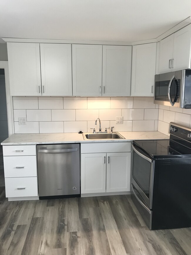 Newly renovated kitchen with white cabinets, subway tile backsplash, and stainless appliances - 430 Main St