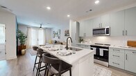 Located at 3712 Stewart Rd in Doraville, GA, this well-appointed one-bedroom, one-bathroom residence offers a thoughtfully designed single-floor layout with modern finishes throughout. The open-concept living and kitchen area serves as the heart of the home, where a large white quartz waterfall island with bar seating flows seamlessly into the kitchen. Sage-green shaker cabinetry with matte black hardware, a white subway tile backsplash, and a full suite of stainless steel appliances—including a French door refrigerator, electric range, and over-the-range microwave—give the kitchen a clean, contemporary character. Light-toned hardwood-style flooring runs throughout, enhancing the bright, airy feel. The living room features a bold dark accent wall, ceiling fan, and French doors that invite natural light. The bedroom is a calm retreat with a soft blue accent wall, a large window with natural light, and direct access to the hallway. The full bathroom offers a soaking tub with shower, white cabinetry with a single-sink vanity, and matte black fixtures. A dedicated laundry area with a stacked Whirlpool washer and dryer adds everyday convenience. Recessed lighting and crisp white walls tie the entire space together with a fresh, modern aesthetic.