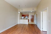 Located at 925 Common St in the heart of downtown New Orleans, this one-bedroom, two-bathroom residence offers a well-designed single-level layout with a thoughtful mix of materials and finishes throughout. The open-concept living, dining, and kitchen area forms the core of the home, anchored by warm hardwood flooring and recessed lighting. A ceiling fan adds comfort to the living space, which benefits from natural light through large windows overlooking the surrounding cityscape. The kitchen features a peninsula with granite-style countertops, warm-toned wood cabinetry, stainless steel appliances including a refrigerator and dishwasher, a double-basin sink, and tile flooring — ideal for both everyday cooking and casual entertaining. The spacious primary bedroom accommodates generous proportions and includes large windows framing urban views, continuing the hardwood flooring found throughout the main living areas. A walk-in closet with wire shelving provides ample storage. The primary bathroom includes a wood-cabinet vanity with granite countertops, tile flooring, and a tiled shower surround. A second full bathroom mirrors the clean, consistent finishes. An in-unit laundry area completes this functional and well-appointed downtown residence.