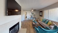 Located at 7007 E Gold Dust Ave in Scottsdale, Arizona, this single-floor residence offers a well-designed layout with a cohesive, contemporary aesthetic throughout. The living room serves as a central gathering space, anchored by a tiled fireplace and wall-mounted television. Wood-look flooring runs through the main living areas, complemented by neutral walls, a ceiling fan, and windows that invite natural light and outdoor views. The dining area connects seamlessly to the kitchen and features sliding glass door access, enhancing the open flow of the space. The kitchen is thoughtfully equipped with white cabinetry, dark countertops, a subway tile backsplash, stainless steel appliances including a refrigerator, dishwasher, microwave, and range, as well as recessed lighting and a window above the sink. Two well-proportioned bedrooms provide comfortable retreats, each with carpeted floors, ceiling fans, and windows overlooking the surrounding greenery. The primary bedroom benefits from direct access to a bathroom featuring wood-look flooring, a vessel sink with dark countertop cabinetry, and a walk-in closet with built-in shelving. This residence combines practical finishes with a clean, modern sensibility in a prime Scottsdale location.