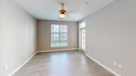 Located at 2120 N Brevard St in Charlotte, NC, this one-bedroom, one-bathroom unit offers a well-designed, efficient layout across a single floor. The open-concept kitchen and living area serves as the heart of the space, featuring light wood-style flooring, large windows, and a glass door providing abundant natural light. The kitchen is outfitted with dark espresso cabinetry, granite countertops, a central island with a built-in sink and pendant lighting, and a full suite of stainless steel appliances including a refrigerator, range, and microwave. The living area benefits from a ceiling fan and windows that overlook the surrounding community. The bedroom is a comfortable, well-proportioned room with soft carpeting, neutral gray walls, and a window that fills the space with natural light. It is complemented by a walk-in closet equipped with wire shelving and hanging rods for ample storage. The full bathroom features wood-style tile flooring, a dark vanity with a granite countertop and dual sinks, a large lighted mirror, and a full tub with subway tile surround. Clean finishes and a neutral color palette unify the space throughout.
