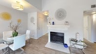 This single-story residence is thoughtfully laid out with an open, connected feel throughout its main living spaces. The living room is a bright, welcoming area benefiting from multiple windows that allow generous natural light to fill the room, complemented by light wood-style flooring that flows seamlessly into the adjacent dining area. A white-mantled fireplace with tile surround serves as a notable focal point, adding warmth and character to the space.

The dining area sits openly alongside the living room and features a window, creating a comfortable space for everyday meals. The galley-style kitchen is efficiently designed with white cabinetry, light stone-look countertops, a grey subway tile backsplash, and stainless steel appliances, including a range, microwave, and dishwasher. Light wood-style flooring continues here, and a separate door provides additional access.

The bedroom is carpeted and generously sized, featuring a sliding glass door that opens directly to a private outdoor patio — a standout feature offering a seamless indoor-outdoor connection. The full bathroom includes a single-sink vanity with white cabinetry, a tub-shower combination, and matching light wood-style flooring, presenting a clean, cohesive aesthetic throughout the home.