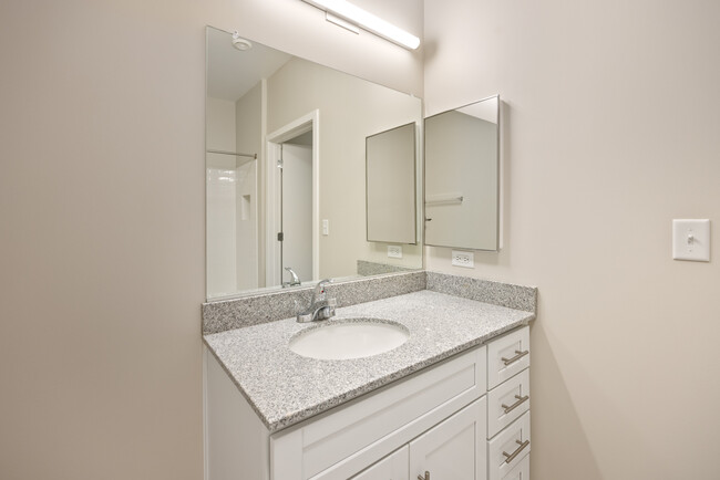 Estilo 1A Tocador de baño con encimeras de granito - Homes at Oxon Hill Senior 62+ Apartments