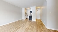 Located at 1379 Princess St in Kingston, Ontario, this 2-bedroom, 1-bathroom unit offers a practical and well-organized layout across a single floor. Light wood-style flooring runs consistently throughout the space, lending a clean and cohesive feel to every room.

The living area is bright and open, featuring large windows with outdoor views of surrounding trees and greenery, complemented by baseboard heating units beneath the sills. Natural light fills the room generously, creating an inviting atmosphere. An adjacent kitchen is efficiently designed with white cabinetry, appliances including a dishwasher, and ceiling-mounted lighting, with an open sightline back toward the living space and entry.

The primary bedroom is a comfortable size, with a window that draws in natural light and connects to a dedicated closet. The second bedroom is more compact, also featuring a window and access to its own closet. A third closet provides additional storage elsewhere in the unit. The bathroom is clean and functional, featuring a white vanity with storage, a toilet, and wood-style flooring consistent with the rest of the home. Neutral grey and white walls throughout maintain a bright, understated aesthetic well-suited to a variety of furnishing styles.
