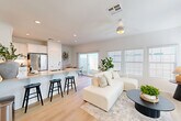 This contemporary 860 square foot home in La Quinta, California offers a thoughtful blend of style and functionality. The single-story layout comprises two bedrooms, including a 140 square foot primary bedroom, and two full bathrooms. The heart of the home is a bright, open-concept living area that seamlessly combines the kitchen and living room. 

The kitchen boasts sleek white cabinetry, stainless steel appliances, and ample counter space, creating an inviting area for meal preparation. The living room features large windows that flood the space with natural light, complemented by a modern ceiling fan and recessed lighting. Light wood flooring throughout adds warmth to the crisp white walls.

Both bathrooms are designed with clean lines and modern fixtures, featuring white vanities with light-colored countertops. The bedrooms offer a tranquil retreat, with the primary bedroom providing generous space and natural light.

Additional amenities include an attached garage and an outdoor patio area, perfect for enjoying the La Quinta climate. The home's efficient use of space and contemporary design elements create a comfortable and stylish living environment.
