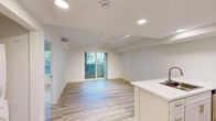 Located at 1277 San Tomas Aquino Rd in San Jose, CA, this 1-bedroom, 1-bathroom unit offers a clean, modern aesthetic across a single floor. Light wood-style flooring runs throughout the entire space, creating a cohesive and bright atmosphere complemented by crisp white walls and recessed lighting.

The open kitchen is a standout feature, anchored by a peninsula with a white quartz countertop and an integrated sink. White shaker-style cabinetry pairs with a full suite of stainless steel appliances, including a gas range, over-the-range microwave, and a full-size refrigerator, providing a functional and attractive cooking space.

The bedroom is a well-proportioned private retreat, benefiting from a large window with blinds that allows ample natural light. A wall-mounted mini-split unit ensures individual climate control, adding to the room's comfort. A track lighting fixture provides focused illumination.

The bathroom continues the clean design language, featuring light wood-look flooring, a wall-mounted sink, and a shower/tub combination adorned with marble-style tile surround. A large mirror with overhead lighting completes the space.

Overall, the unit presents a fresh, move-in-ready interior with consistent, modern finishes throughout.