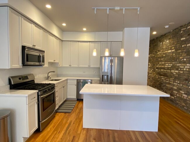 Beautiful white kitchen with stainless steel appliances and large island - 3546 N Janssen Ave