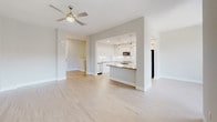 This two-story residence in Irvine, California offers a clean, contemporary design with a neutral color palette throughout. The open-concept main level features a spacious living area with light wood-style flooring and a ceiling fan, flowing seamlessly into a well-equipped kitchen. The kitchen is outfitted with white shaker cabinetry, dark quartz countertops, a subway tile backsplash, stainless steel appliances including a gas range and dishwasher, and a peninsula that provides additional workspace and casual seating. A half bathroom on the main level features wood-tone counters, white cabinetry, and backlit mirrors. The upper level hosts generously sized bedrooms, each carpeted and equipped with ceiling fans. Bedrooms benefit from large windows that bring in natural light and views of the surrounding community. The full bathrooms are finished with light tile flooring, white vanity cabinetry, warm-toned countertops, and backlit mirrors, with one bathroom featuring a full soaking tub and shower combination. The overall ambiance is bright, clean, and move-in ready, reflecting a modern aesthetic well-suited for comfortable living in the heart of Irvine.