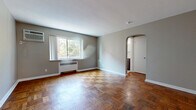Located at 2217 Victory Pkwy in Cincinnati's vibrant East Walnut Hills neighborhood, this two-bedroom, one-bathroom unit offers a thoughtfully arranged single-floor layout. The living room is a welcoming, open space highlighted by classic parquet hardwood flooring that adds warmth and character throughout. Natural light streams in through a wide window offering views of surrounding greenery, complemented by a wall-mounted air conditioning unit and a baseboard heating system. A charming arched doorway connects the living area to the rest of the unit, adding an architectural detail that enhances the overall flow.

The kitchen features dark wood cabinetry, light countertops, and tile flooring, and is equipped with a stainless steel gas range and refrigerator. A door in the kitchen provides direct exterior access, adding everyday convenience.

Both bedrooms continue the parquet hardwood flooring found in the living area. The primary bedroom is a comfortable, well-proportioned space, while the second bedroom includes a ceiling fan and a window allowing natural light. The bathroom is clean and functional, featuring tile flooring, a sliding glass shower enclosure with subway tile surround, and a wood-toned vanity. A dedicated entrance and hallway complete the layout, providing a practical and organized flow throughout the home.