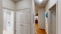 This well-designed 2-bedroom, 3-bathroom residence at 472 Providence Main St NW in Huntsville, Alabama offers a thoughtfully organized single-floor layout. The inviting living room features rich hardwood flooring, crown molding, a ceiling fan, and a front door flanked by windows dressed in sheer white curtains that allow generous natural light to fill the space. The kitchen is outfitted with rich dark wood cabinetry extending to the ceiling, light granite-style countertops, a white subway tile backsplash, and a full suite of stainless steel appliances, including a refrigerator, range, microwave, and dishwasher. Hardwood floors continue through the kitchen, adding warmth and continuity. The primary bedroom is a comfortable retreat with plush carpeting, a ceiling fan, and bright windows. The second bedroom mirrors this comfort with carpeted floors and its own ceiling fan. Both rooms offer a calm, neutral color palette. The bathrooms are finished with light tile flooring, a glass-enclosed shower, a soaking tub, and wood-toned vanities. A hallway closet with double panel doors and a walk-in closet featuring multi-tiered wire shelving provide ample storage. The neutral-toned walls throughout create a clean, cohesive aesthetic ideal for a variety of styles.