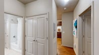 This well-designed 2-bedroom, 3-bathroom residence at 472 Providence Main St NW in Huntsville, Alabama offers a thoughtfully organized single-floor layout. The inviting living room features rich hardwood flooring, crown molding, a ceiling fan, and a front door flanked by windows dressed in sheer white curtains that allow generous natural light to fill the space. The kitchen is outfitted with rich dark wood cabinetry extending to the ceiling, light granite-style countertops, a white subway tile backsplash, and a full suite of stainless steel appliances, including a refrigerator, range, microwave, and dishwasher. Hardwood floors continue through the kitchen, adding warmth and continuity. The primary bedroom is a comfortable retreat with plush carpeting, a ceiling fan, and bright windows. The second bedroom mirrors this comfort with carpeted floors and its own ceiling fan. Both rooms offer a calm, neutral color palette. The bathrooms are finished with light tile flooring, a glass-enclosed shower, a soaking tub, and wood-toned vanities. A hallway closet with double panel doors and a walk-in closet featuring multi-tiered wire shelving provide ample storage. The neutral-toned walls throughout create a clean, cohesive aesthetic ideal for a variety of styles.