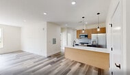 Located at 448 S Orange Ave in Newark, NJ, this thoughtfully designed 2-bedroom residence offers a clean, modern aesthetic across a well-utilized single floor. Light-toned wood-look flooring runs throughout the entire unit, creating a cohesive and contemporary feel from room to room.

The open-concept kitchen and living area serves as the heart of the home. The kitchen is outfitted with warm natural wood cabinetry, white quartz countertops, a classic subway tile backsplash, and stainless steel appliances including a gas range, microwave, and refrigerator. A large kitchen island with pendant lighting provides both additional prep space and a casual dining option, making the kitchen as functional as it is stylish.

The two bedrooms are bright and well-proportioned, with the primary bedroom offering generous space and a double-door closet with matte black hardware. Both bedrooms feature large windows that invite natural light and offer views of the surrounding Newark neighborhood. Recessed lighting and neutral white walls throughout the unit enhance the airy, move-in-ready atmosphere. The layout is efficient and practical, making excellent use of the available space while maintaining an open, uncluttered feel.