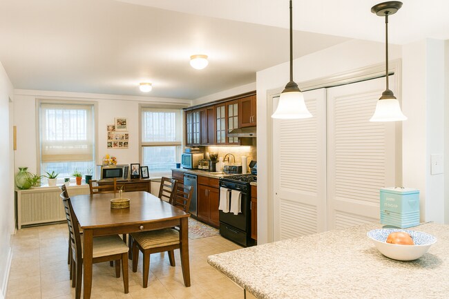 Cocina moderna con campana extractora ventilada, lavavajillas incorporado y amplio espacio para gabinetes. - 56 Jefferson Ave