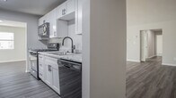 This single-floor residence on Pinewood Drive in Yorktown, Virginia offers a clean, updated interior designed for comfortable everyday living. The open living area is among the most notable spaces, featuring wood-style plank flooring and a large sliding glass door that fills the room with natural light while providing outdoor access. An adjacent area with matching flooring connects seamlessly to the rest of the home, creating a functional flow throughout.

The kitchen is well-appointed with white shaker-style cabinetry, granite-look countertops, a stainless steel sink with a matte black faucet, and black appliances including a gas range with oven and an over-the-range microwave. The neutral palette and modern hardware give the kitchen a fresh, contemporary feel.

The bedrooms are carpeted and generously sized, with windows that bring in natural light. At least one bedroom features dual closets, providing ample storage. The primary bedroom includes an en-suite bathroom and walk-in closet access. The bathroom is finished with a white vanity, solid-surface countertop, and matte black fixtures with a large mirror above.

A dedicated laundry area is visible within the floor plan. Throughout the home, neutral gray-beige wall tones, clean white trim, and consistent finishes contribute to a cohesive, move-in-ready aesthetic.