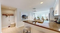Located at 705 W 9th St in the heart of downtown Los Angeles, this thoughtfully designed three-bedroom, two-bathroom residence offers a refined urban living experience across a single floor. The open-concept layout seamlessly connects the living, dining, and kitchen areas, creating a bright and airy atmosphere anchored by expansive floor-to-ceiling windows that frame striking city skyline views and flood the space with natural light.

The living area is generous and welcoming, featuring light hardwood flooring that flows throughout the home. The kitchen is well-appointed with white shaker cabinetry, rich stone countertops, a breakfast bar with seating, stainless steel appliances, and a subway tile backsplash. The adjacent dining area enjoys direct skyline views, adding an elevated backdrop to everyday meals.

Each bedroom is comfortably proportioned, with the primary bedroom offering large windows that bring in ample natural light. The bathrooms are clean and modern, with one featuring a glass-enclosed walk-in shower with stone tile flooring. Two closets provide practical storage throughout the residence. A well-connected hallway links the private and common areas with ease, completing this polished downtown Los Angeles home.