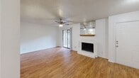 Located in Austin's vibrant 78704 zip code, this 2-bedroom, 2-bathroom single-floor residence offers a well-organized and functional layout. The open living area is a standout feature, showcasing warm wood-look flooring that extends throughout the home, a white brick fireplace with a wood mantel, and a ceiling fan. Sliding glass doors lead to an outdoor area, allowing natural light to fill the space. The living room flows seamlessly into the dining area, which connects to the kitchen via a pass-through counter. The kitchen is efficiently designed with white cabinetry, white appliances including a refrigerator and dishwasher, a sink, and ample counter space. A dedicated laundry room with washer/dryer hookups and shelving adds convenience. The spacious primary bedroom features a ceiling fan, a closet, and an en-suite bathroom. The second bedroom includes a window with natural light and its own closet. Both bathrooms are clean and bright, with one featuring a tub/shower combination. Textured ceilings are consistent throughout the home, complementing its neutral white walls and cohesive aesthetic.