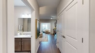 This single-story residence in Little Rock, Arkansas, presents a thoughtfully designed layout that balances comfort and modern style. Rich hardwood-style flooring flows continuously throughout the unit, creating visual cohesion from the entry corridor to the living and sleeping areas. Neutral gray-toned walls provide a clean, versatile backdrop that complements the overall contemporary aesthetic.

The kitchen is well-appointed with stainless steel appliances, including a range, over-the-range microwave, and refrigerator, paired with granite-style countertops and taupe shaker-style cabinetry offering ample storage. The kitchen opens directly to the living area, which is generously proportioned and filled with natural light, creating an inviting space for everyday living.

The bedroom is a serene retreat, featuring a ceiling fan, natural light from well-positioned windows, and direct sightlines to both the kitchen and the hallway. A walk-in closet provides practical storage. The bathroom features a vanity with granite-style countertops, dark cabinetry, and a clean, neutral finish, while a separate water closet adds privacy and functionality. The entry hallway connects all areas efficiently, reinforcing the unit's smart, open flow.