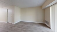 This one-bedroom, one-bathroom residence in Carnot, PA offers a well-organized single-floor layout designed for comfortable everyday living. The open living room is bright and welcoming, finished with light hardwood-style flooring, clean white baseboards, and neutral cream-toned walls that create an airy, versatile backdrop. A ceiling fan anchors the combined living space, adding both function and style.

The galley-style kitchen is efficiently designed with ample white cabinetry, granite-style countertops, and a full suite of stainless steel appliances including a refrigerator, electric range, over-the-range microwave, and dishwasher. Light flooring continues throughout, maintaining visual continuity between the kitchen and living areas.

The bedroom is a comfortable, private retreat featuring plush carpeting, a window with a view to the outdoors providing natural light, and a built-in closet with louvered bi-fold doors offering generous storage. The bathroom includes a full soaking tub and shower combination with clean, tiled surround walls in a neutral palette. A hallway connects the rooms, contributing to a practical and intuitive flow throughout the residence. The overall aesthetic is clean, neutral, and move-in ready.
